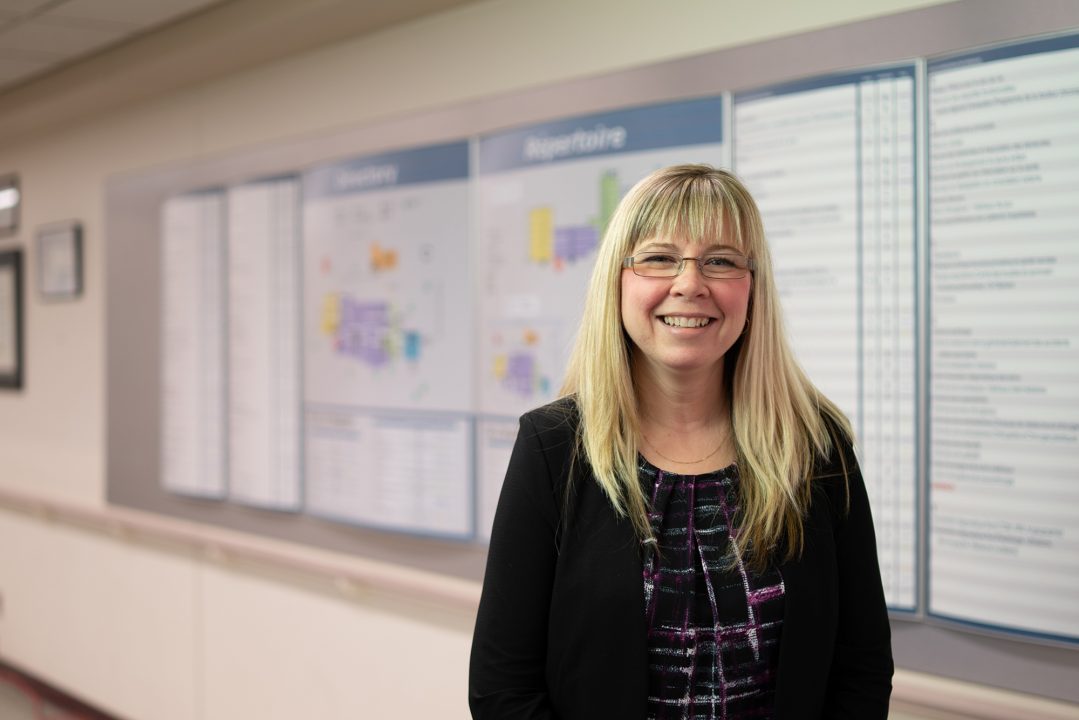 Jessica Grenier stands in front of a wayfinding sign at Health Sciences North in Sudbury, Ontario.